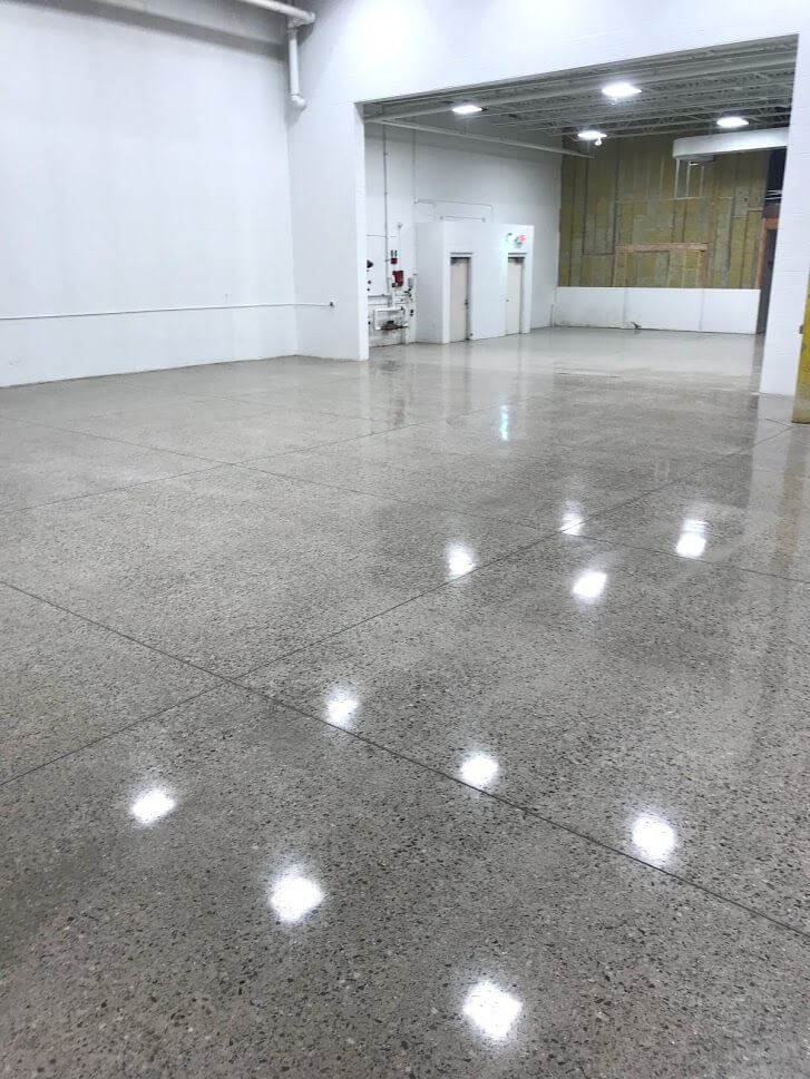 A shiny industrial floor polished by B&B Concrete as part of their specialty services that include floor polishing, floor flattening, and floor evaluation
