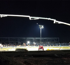 A construction site lit up at night as workers continue to work