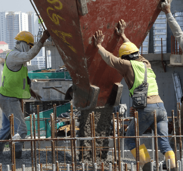 CAT backhoes digging or cleaning a flat ground surface to prep it for concrete